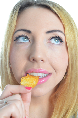 Young woman eating crisps isolatedの写真素材