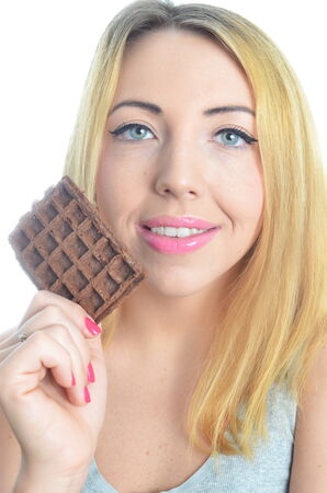 Young woman eating chocolate waffle isolatedの写真素材