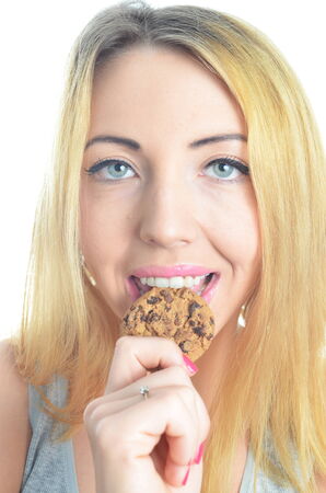 Young woman eating cookie isolatedの写真素材