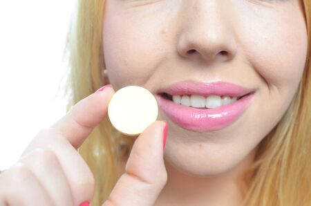 Woman taking big pill isolatedの写真素材