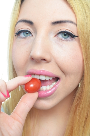 Young woman with healthy tomato isolatedの写真素材