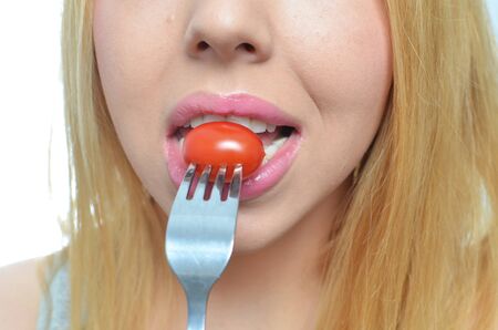Young woman with healthy tomato isolatedの写真素材