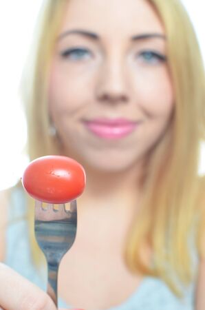 Young woman with healthy tomato isolatedの写真素材