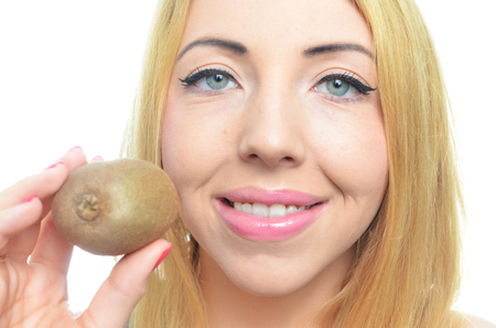 Young woman with fresh kiwi fruit isolatedの写真素材