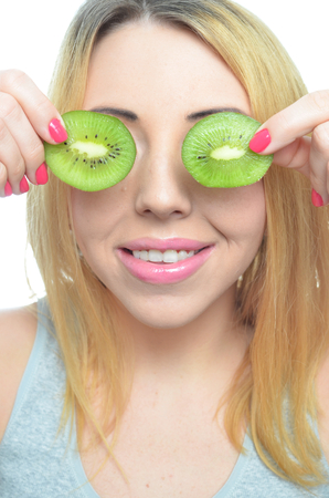 Young woman with fresh kiwi fruit isolatedの写真素材