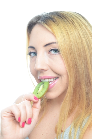 Young woman with fresh kiwi fruit isolatedの写真素材