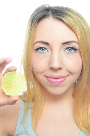 Young woman with sliced lime isolatedの写真素材
