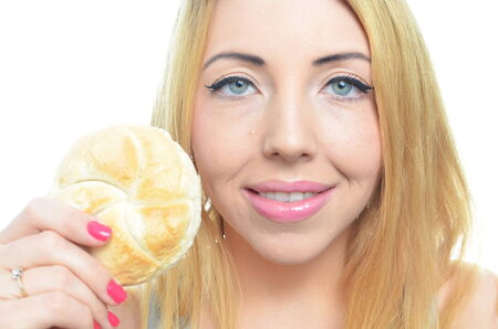 Woman eating bread roll isolatedの写真素材