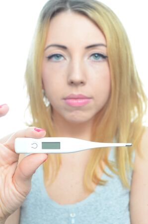 Young woman taking temperature and pills isolatedの写真素材