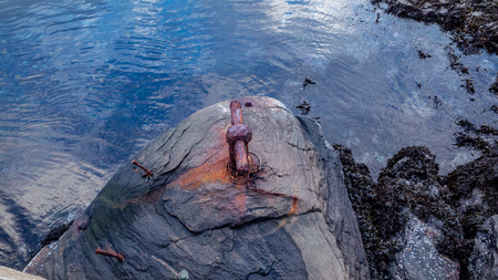 Old bollard on rock, view from top.の写真素材