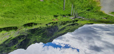 Aerial panoramic view of the green hills and reflection in a lake.の写真素材