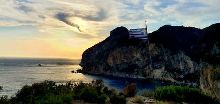 Flag on the background of the sea and the sunset.