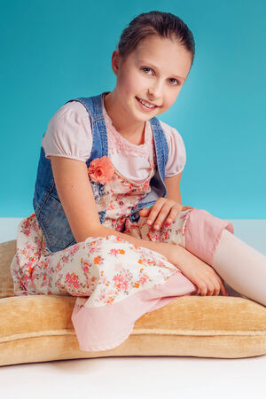 Pretty young smiling girl posing, looking at camera. Studio shot.の写真素材