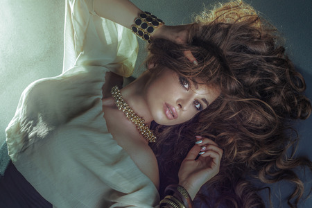 Beauty portrait of sensual brunette woman. Girl looking at camera, wearing fashionable necklace.の写真素材