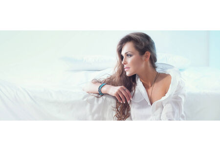 Beautiful young woman relaxing in bedroom. Indoor shot.の写真素材