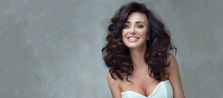 Smiling beautiful brunette woman posing in studio, elegant style.の写真素材