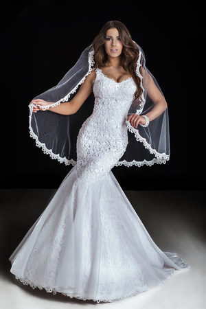 Beautiful brunette woman posing in fashionable white wedding dress. Studio shot.の写真素材