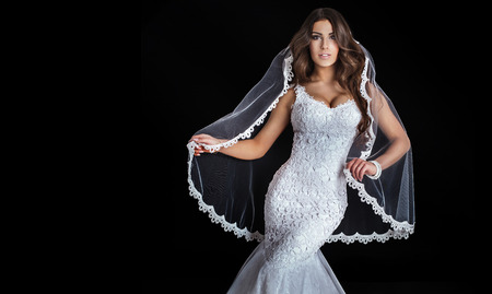 Beautiful brunette woman posing in fashionable white wedding dress. Studio shot.の写真素材