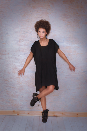 Fashionable afro woman posingin studio, smiling to the camera.の写真素材