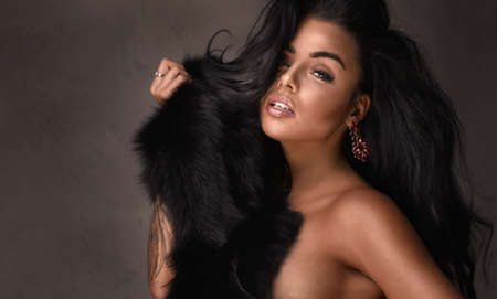 Beauty portrait of sexy woman with jewelry and long black hair.の写真素材