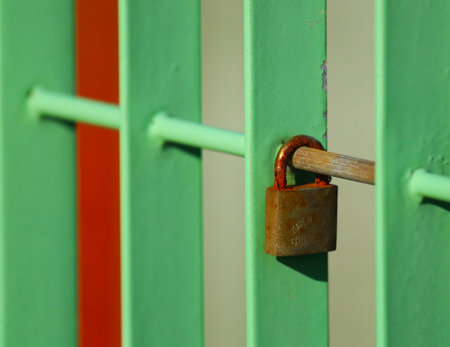 Padlock on a green wooden gate. Close up. Selective focus.の写真素材