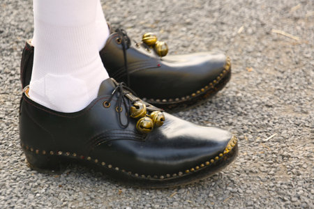 feet in black leather shoes on the gravel road.