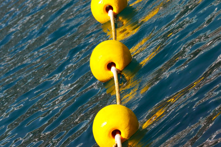Yellow mooring bollards in the sea, closeup of photo