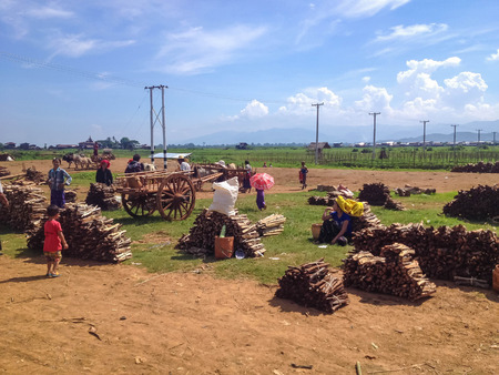NYAUNG SHWE, MYANMAR - MAY 26 : Local residents sell firewood at the friday market on May 26, 2014 in Nyaung Shwe, Lake Inle, Myanmar.Wood is the main heating material in Burma.のeditorial素材