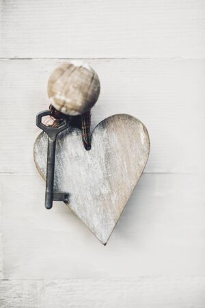 Key with wooden heart hanged on the door handleの写真素材