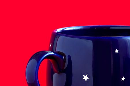 Blue coffee cup with stars  on a red backgroundの写真素材