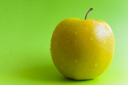 Yellow apple on a green backgroundの写真素材