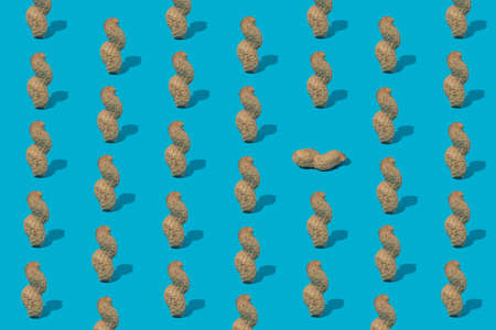 Creative design of a pattern with peanuts photographed on a bright blue backgroundの写真素材