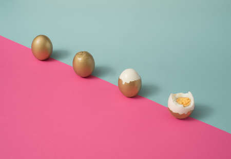 Creative design of traditional Easter egg painted in gold, broken and eaten, photographed on bright...