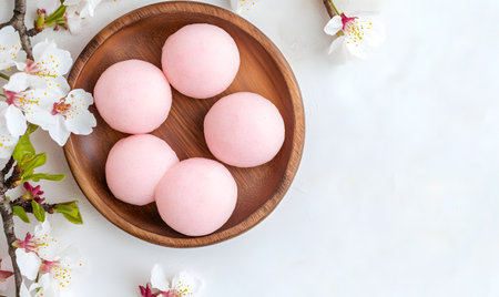 Bowl of pink Japanese mochi on a white background.の素材