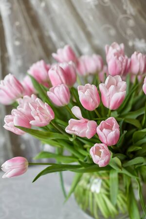 Decor and a vase with pink tulips on a table. Selective focus.の写真素材