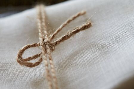 Twine tied in a bow. Close-up. Fabric backgroundの写真素材