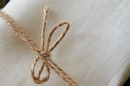 Twine tied in a bow. Close-up. Fabric backgroundの写真素材
