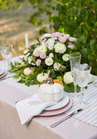 Table setting with beautiful autumn decorand with white mini pumpkinsの写真素材