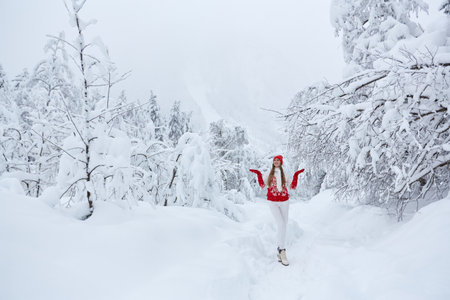 Young caucasian girl in red hat, mittens and knitted sweaterの写真素材