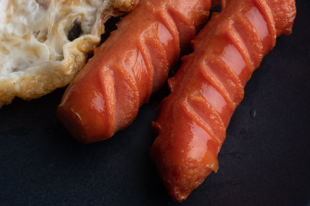 Simple breakfast set with fried egg sunny side up and grilled sausages.の写真素材