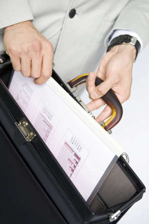 Hand of office worker taking out a document from his bagの写真素材