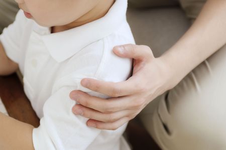 Hand touching boy\'s shoulderの写真素材