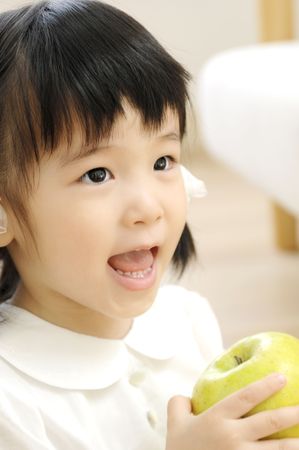 Girl having an appleの写真素材