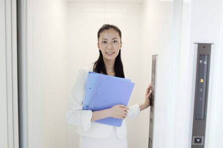 Business lady standing in elevatorの写真素材