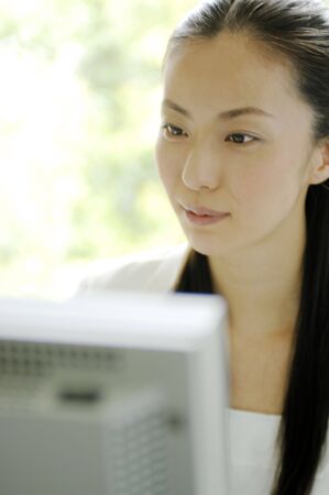 Business lady sitting down in front of PC monitorの写真素材