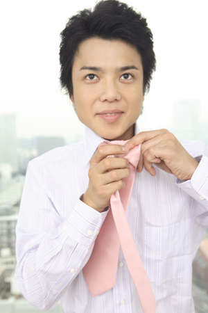 Businessman putting on a tieの写真素材