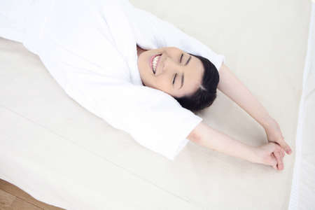 Woman stretching on the bedの写真素材