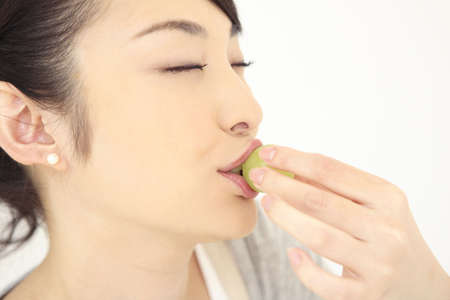 Woman eating a grapeの写真素材
