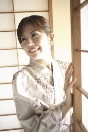 Japanese woman putting on kimonoの写真素材