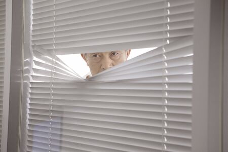 President looking in the room from a window shadeの写真素材